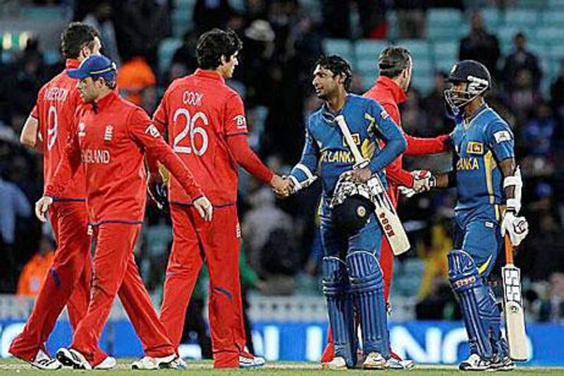 England's captain Alastair Cook, third left shakes hand with Sri Lanka's Kumar Sangakkara following their defeat. Alastair Grant / AP Photo