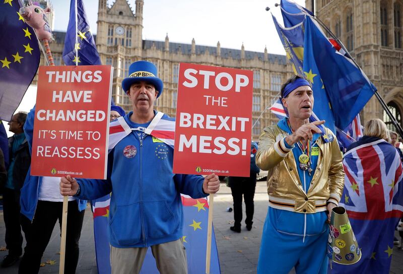 Anti-Brexit demonstrators protest outside Parliament as British PM Theresa May was attending Prime Minister's questions in London, Wednesday, Nov. 14, 2018. British Prime Minister Theresa May will try to persuade her divided Cabinet on Wednesday that they have a choice between backing a draft Brexit deal with the European Union or plunging the U.K. into political and economic uncertainty. (AP Photo/Matt Dunham)