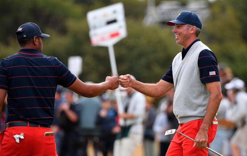 Matt Kuchar (R) and Tony Finau bump fists during the third day of the Presidents Cup. AFP