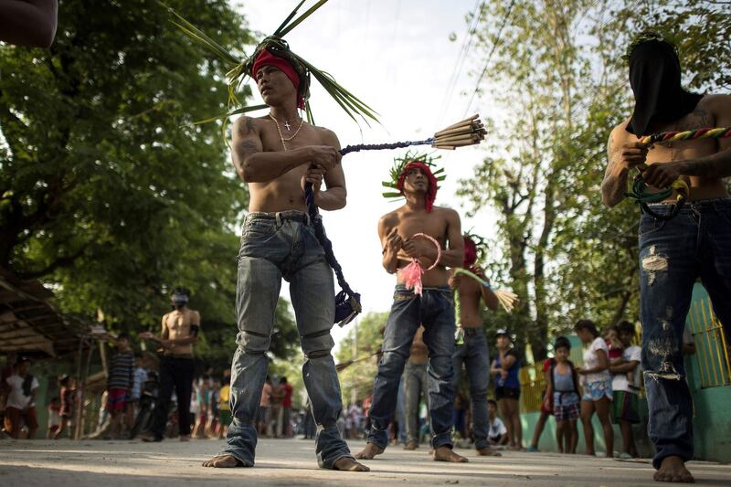 Flagellant RJ Riverawhips his back as part of his penitence during the re-enactment of the crucifixion of Jesus Christ for Good Friday celebrations ahead of Easter in the village of San Juan, Pampanga, north of Manila. Noel Celis / AFP Photo