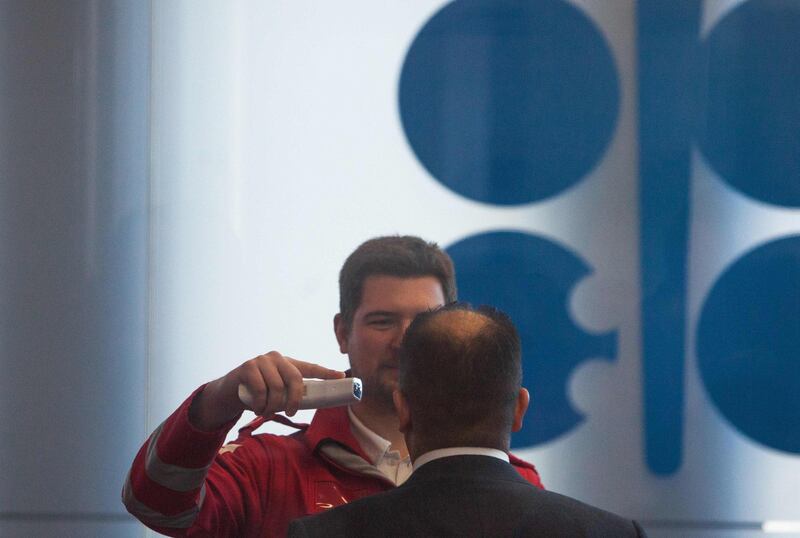 A Red Cross medic measures the temperature of a participant of the 178th Organization of Petroleum Exporting Countries (OPEC) meeting in Vienna, Austria, on March 5, 2020.  Delegates from oil-producing countries started arrived in Vienna to discuss output cuts in a meeting overshadowed by worries over the new coronavirus -- both its affect on oil prices as well as a big gathering like OPEC. / AFP / ALEX HALADA
