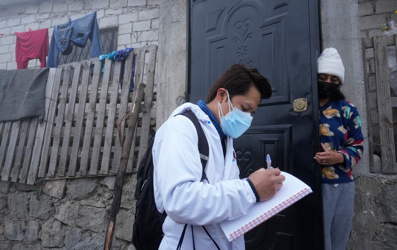 A doctor prescribes medicine for a person infected with Covid-19, in Quito, Ecuador. AP