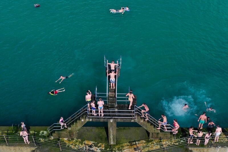 People enjoy paddling in a seawater pool on the beach of Saint Malo, north-western France. AFP