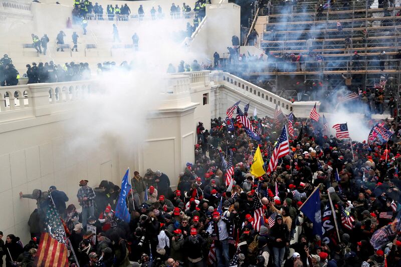 The pro-Trump mob swarms the Capitol as police release tear gas. Reuters
