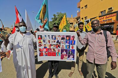 People march with a sign showing the portraits of fallen demonstrators in the centre of Sudan's capital Khartoum on November 30, 2021 while protesting against a deal that saw the civilian prime minister reinstated after the military coup in October. AFP