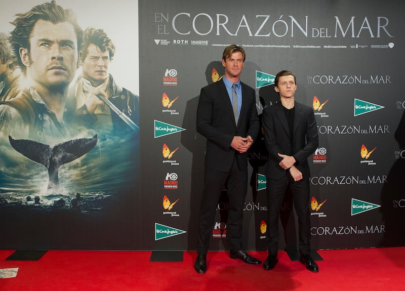 Chris Hemsworth and Tom Holland, in a black suit and T-shirt, attend the 'In the Heart of the Sea' premiere in Madrid on December 3, 2015. Getty Images