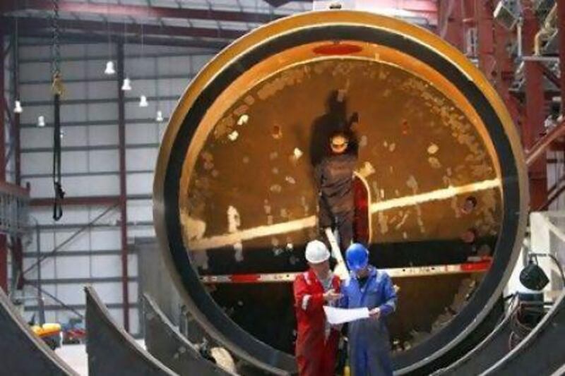 Workers install the interior of a wave energy converter at the Pelamis Wave Power site in Leith, Edinburgh, Scotland. Reuters