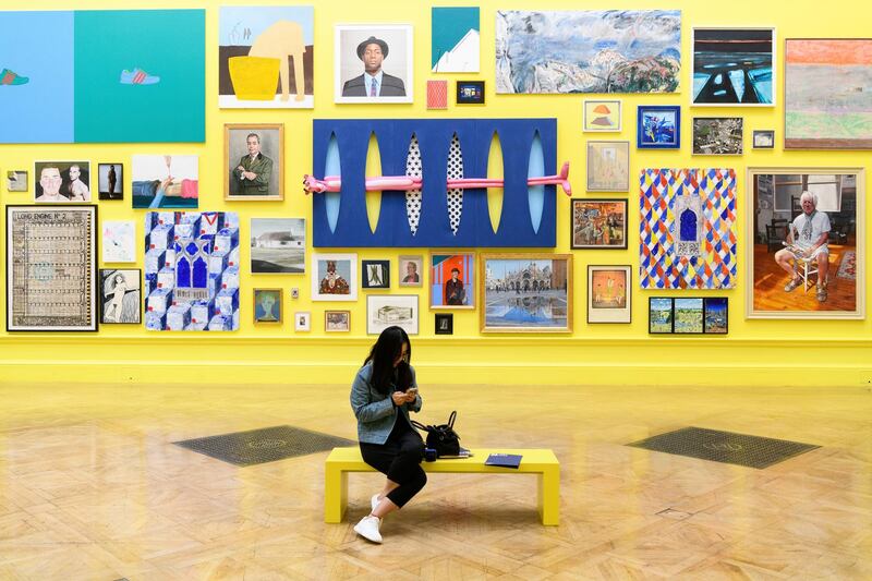 LONDON, ENGLAND - JUNE 05:  A woman sits in front of a selection of the artworks on display during a press preview of the 250th Summer Exhibition at Royal Academy of Arts on June 5, 2018 in London, England.  The Summer Exhibition runs from 12 June to 19 August 2018 and allows established and emerging artists to display their work, side by side, with all forms of contemporary art, including such mediums as sculpture, painting, video installation and textile.  (Photo by Leon Neal/Getty Images)