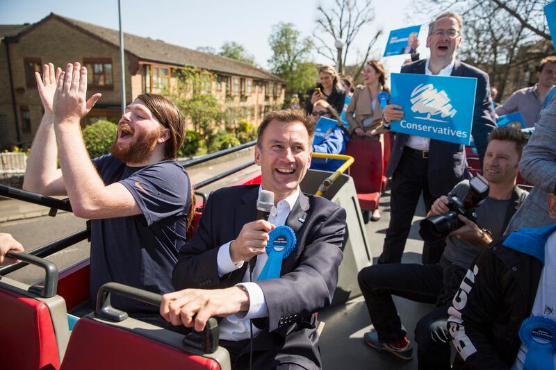 Mr Hunt joins local Conservative Party activists as they campaign on the constituency's battle bus in Thurrock in 2015. Getty