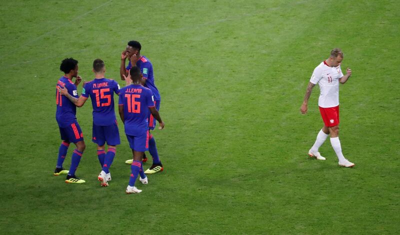 Soccer Football - World Cup - Group H - Poland vs Colombia - Kazan Arena, Kazan, Russia - June 24, 2018   Colombia players celebrate as Poland's Kamil Grosicki looks dejected after the match    REUTERS/Jorge Silva