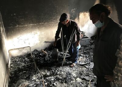 Lyazid Tazibt stands with his brother Khelaf inside their home that was burnt following a wildfire in the village of Ait Sid Ali, in the northeastern Bejaia province, Algeria.