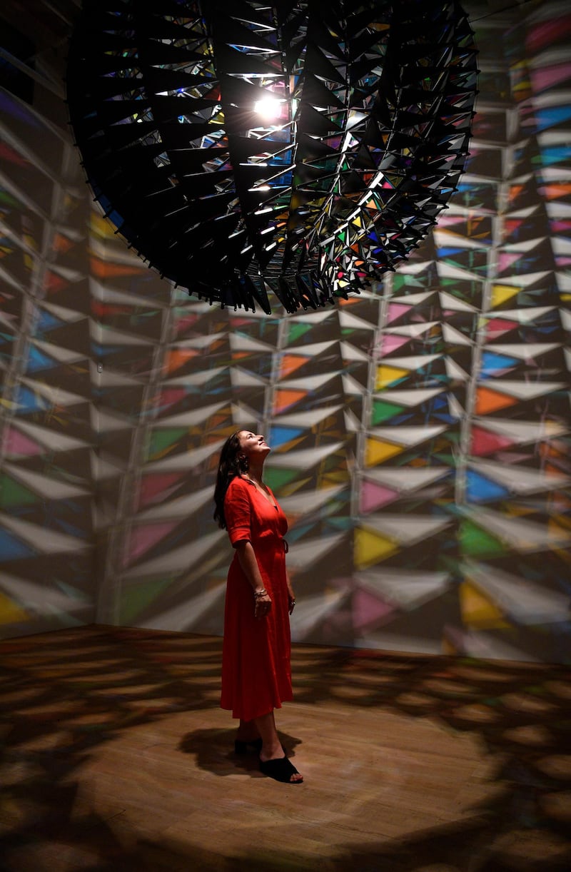 A woman poses with Danish-Icelandic artist Olafur Eliasson's work 'Cold Wind Sphere' (2012). Photo: EPA