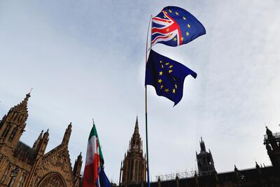 A Pro-European demonstrator raises flags to protest outside parliament in London, Friday, Jan. 11, 2019. Britain's Prime Minister Theresa May is struggling to win support for her Brexit deal in Parliament. Lawmakers are due to vote on the agreement Tuesday, and all signs suggest they will reject it, adding uncertainty to Brexit less than three months before Britain is due to leave the EU on March 29. (AP Photo/Frank Augstein)