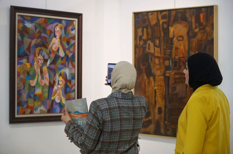 Visitors take pictures of some of the hundreds of works on display.