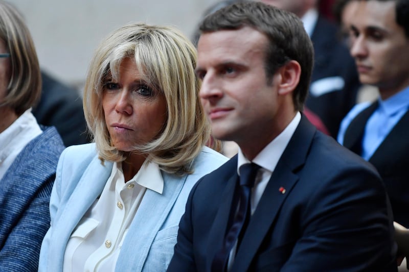 In this photo dated Tuesday, July 25, 2017, French First Lady Brigitte Macron and French President Emmanuel Macron attend a concert from the Pierre Claver association at the Elysee Palace in Paris, France. (Julien de Rosa/Pool Photo via AP)