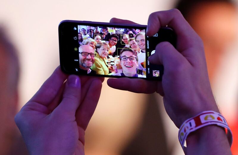 German chancellor Angela Merkel is pictured on a mobile phone as she attends a breakfast with supporters at the Christian Democratic Union (CDU) party election campaign meeting centre in Berlin, Germany. Fabrizio Bensch / Reuters