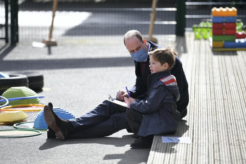 LONDON, ENGLAND - MARCH 11: Prince William, Duke of Cambridge, speaks to a young pupil in the playground during a visit to School 21 in Stratford on March 11, 2021 in London, England. The Duke and Duchess of Cambridge visited the school in east London to congratulate teachers involved in the re-opening of the school following lockdown restrictions. (Photo by Justin Tallis - WPA Pool/Getty Images)