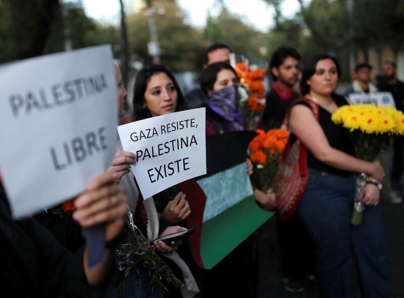 Protesters hold placards that read 'Gaza resists, Palestine exists' and 'Free Palestine' outside the Israel embassy in Mexico City. Reuters