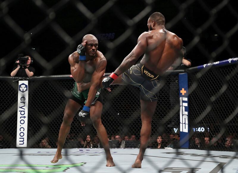 Kamaru Usman attempts to block a kick from Leon Edwards during their welterweight title bout at UFC 286. PA