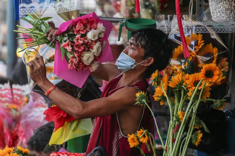 A vendor makes a flower bouquet at a market in Manila. AFP