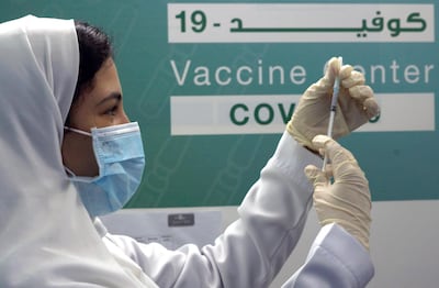 Saudi physician Hala Alkattan prepares to inject a Pfizer vaccine at a new coronavirus vaccination center, at the Jiddah old airport, Saudi Arabia, Thursday, Jan. 14, 2021. The Saudi Ministry of Health called on citizens and residents to take the vaccine for free. (AP Photo/Amr Nabil)