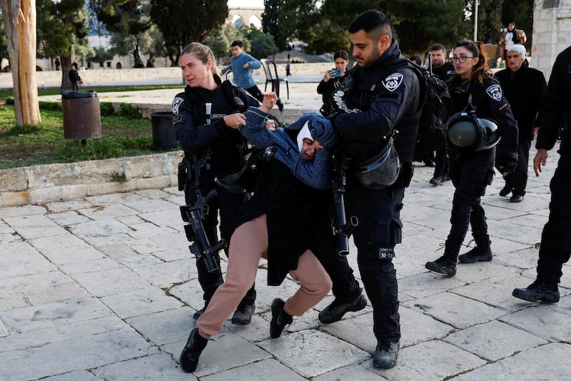 Israeli police detain a woman during a raid on the Al Aqsa compound in Jerusalem's Old City on April 5, 2023. Reuters
