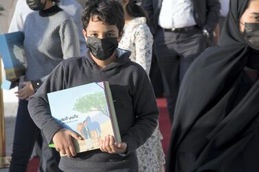 A boy with his copy of Sheikh Mohammed bin Rashid, Vice President and Ruler of Dubai's book 'My Little World' at the Emirates Airline Festival of Literature. Leslie Pableo / The National 