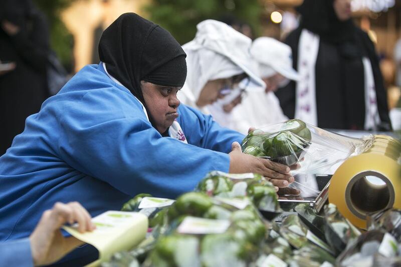 A young woman packages vegetables at one of the job stations set up at Yas Mall in celebration of Down Syndrome Day. Mona Al Marzooqi/ The National