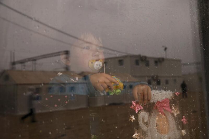 A migrant child looks through a window at the Macedonian-Serbian border near the village of Tabanovce, Macedonia. Marko Djurica / Reuters