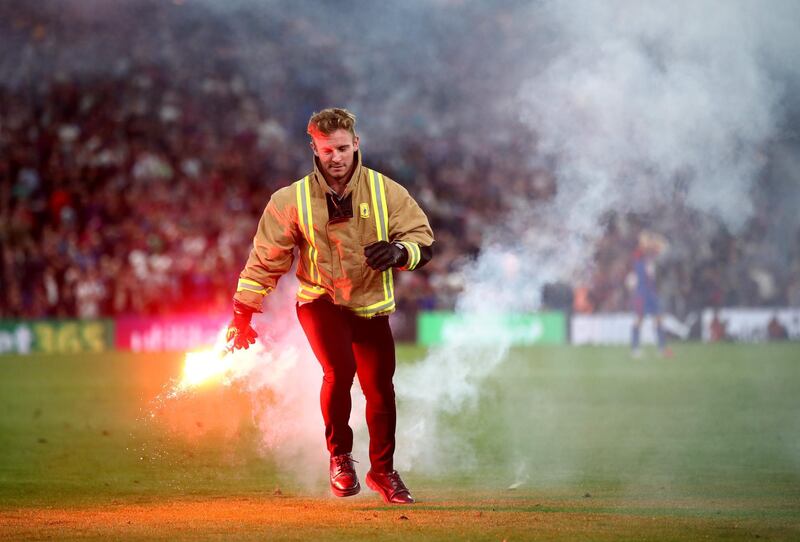 A steward removes a flare from the pitch. Getty Images
