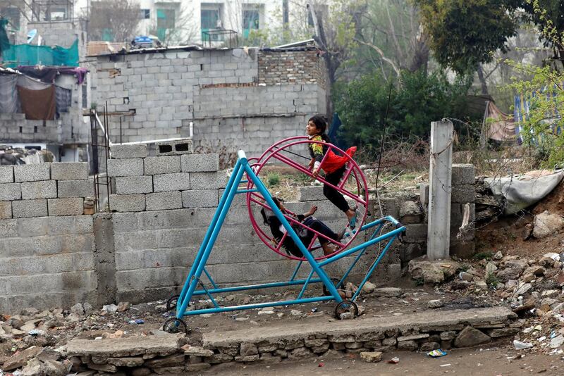 Seven-year old Aroosh, rides on a swing with her friends in Islamabad, Pakistan. Reuters