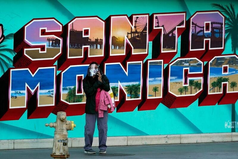 A commuter wears a faces shield and mask across the street from a train station amid the COVID-19 pandemic, in Santa Monica, California. AP Photo