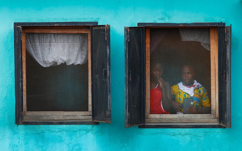 Liberian girls look out a window to see presidential candidate George Weah from the Congress for Democratic Change (CDC) party as he passes in a cavalcade during a campaign rally in Buchanan, Liberia. Nic Bothma / EPA
