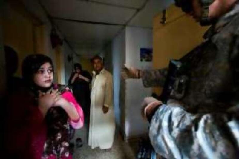 US and Iraqi Army soldiers search an apartment block in the Qadasiya neighborhood of Mahmoudiya, hunting for members of so-called Iranian special groups, Shiite militants who have refused to abide by a ceasefire with the Iraqi government, Friday, October 17, 2008. *** Local Caption ***  house raid fear.jpg