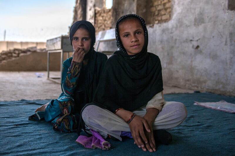 Aisha, 9, (in the background) sits with her friend Rapia, 10, at Assad Suri Primary School. The girls are one of the few attending the school, hoping to become teachers themselves one day to teach ohter girls. 