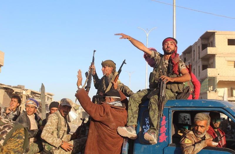 Syrian Democratic Forces (SDF) fighters sit on their pickup as they prepare for the last battle against ISIL in Raqqa, Syria. Syrian Democratic Forces via AP