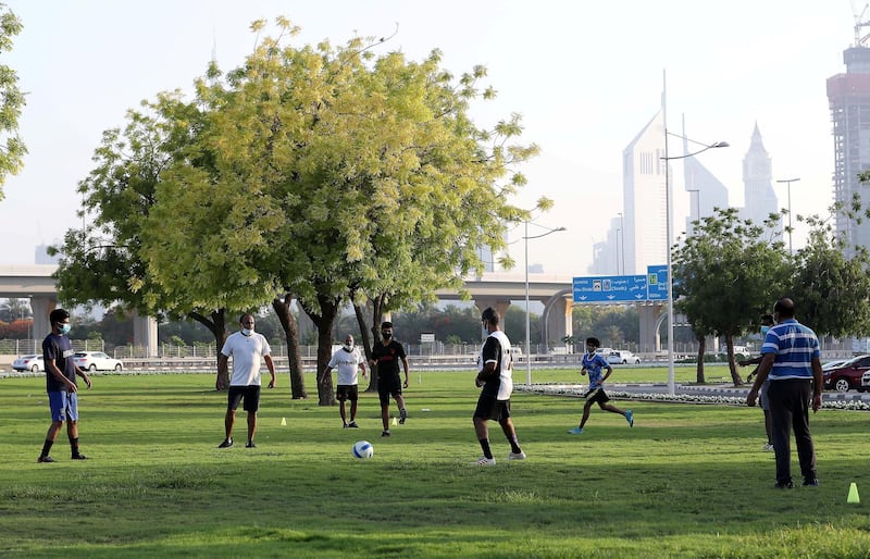 DUBAI, UNITED ARAB EMIRATES , May 27 – 2020 :- People wearing protective face mask as a preventive measure against the spread of coronavirus and playing football in the green area outside the closed Zabeel park in Dubai. (Pawan Singh / The National) For News/Online/Stock/Instagram