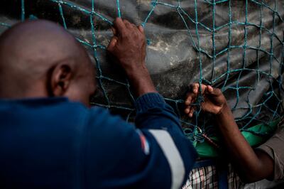 oMalayitsha (transporters) load goods onto a trailer in central Johannesburg to be taken across the border to clients in Zimbabwe on February 20, 2019.  Items are loaded in Johannesburg onto trailers attached to minibuses which make the 550 kilometres (340 miles) journey north to the border of Zimbabwe, where economic situation has dramatically deteriorated, pushing inflation above 50 percent, and shortages of household essentials have become widespread. / AFP / GULSHAN KHAN 
