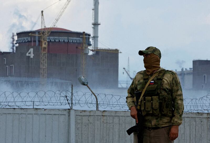 A serviceman with a Russian flag on his uniform stands guard near the Zaporizhzhia nuclear power plant in Ukraine. Reuters