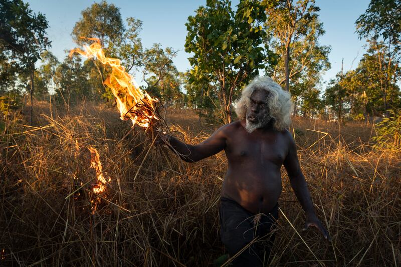 The photo which won the World Press Photo Story Of The Year award by Matthew Abbott for National Geographic Magazine/Panos Pictures, titled Saving Forests With Fire, shows Nawarddeken elder Conrad Maralngurra burns grass to protect the Mamadawerre community from late-season 'wildfires', in Mamadawerre, Arnhem Land, Australia, May 3, 2021.  The late-evening fire will die out naturally once the temperature drops and moisture levels rise. Matthew Abbott for National Geographic / Panos Pictures / World Press Photo