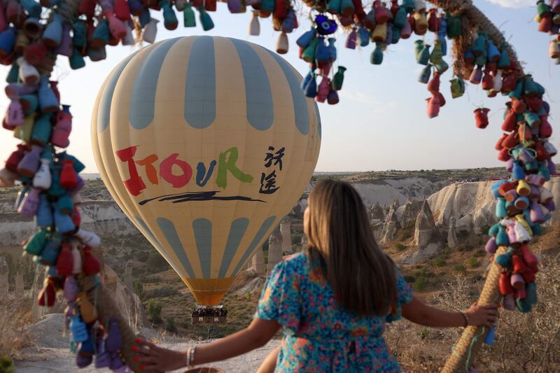 A woman watches as a sight-seeing hot air balloon is launched.