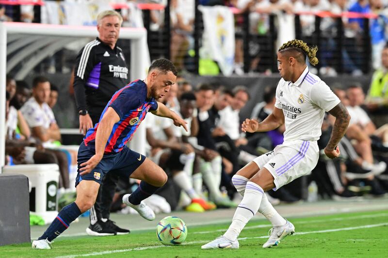 Real Madrid coach Carlo Ancelotti watches as Sergino Dest of Barcelona vies for the ball with Mariano Diaz of Real Madrid. AFP