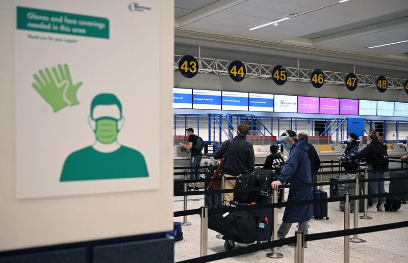 Passengers queue at a check-in desk at Manchester Airport. AFP