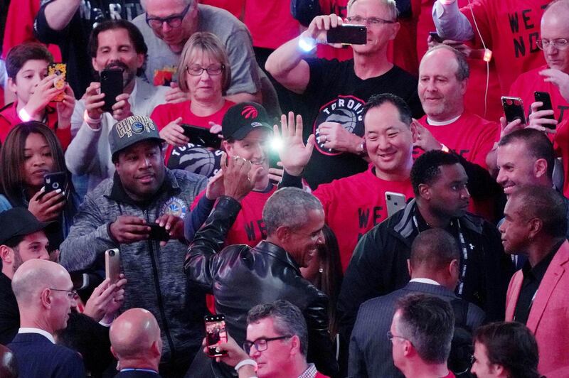 Former US president Barack Obama high fives fans before the game. Reuters