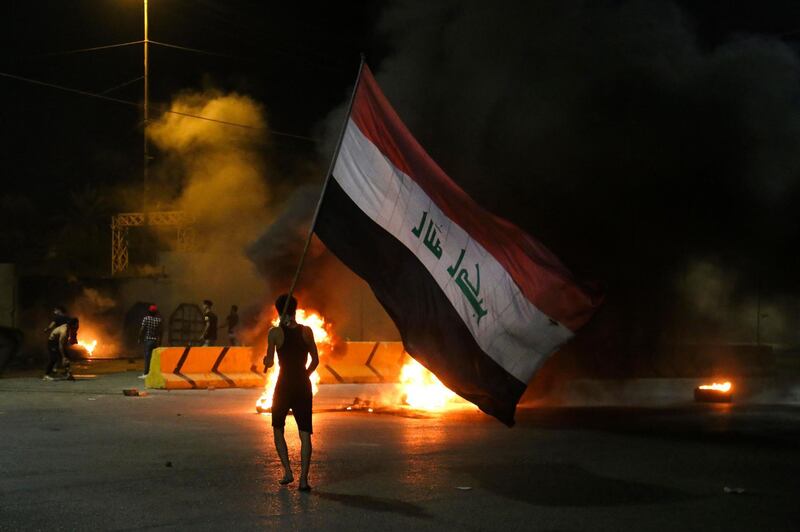 TOPSHOT - Iraqi protesters burn tyres in front of the Karbala governorate headquarters in the central  city of Karbala, early on May 9, 2021, following the reported assassination of a local anti-government activist. Renowned anti-government activist Ihab al-Wazni (Ehab al-Ouazni) was killed in Iraq early today, security sources and activists said, sending supporters of a protest movement onto the streets to demand an end to bloodshed. / AFP / Mohammed SAWAF
