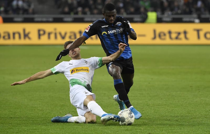 Moenchengladbach's German forward Patrick Herrmann (L) and Paderborn's Jamilu Collins vie for the ball during the German first division Bundesliga football match Borussia Moenchengladbach v SC Paderborn, on December 18, 2019 in Moenchengladbach. (Photo by INA FASSBENDER / AFP) / DFL REGULATIONS PROHIBIT ANY USE OF PHOTOGRAPHS AS IMAGE SEQUENCES AND/OR QUASI-VIDEO