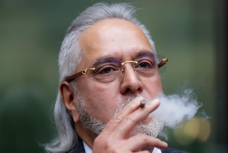 FILE - In this Monday, Dec. 10, 2018 file photo, Indian business man Vijay Mallya takes a smoking break outside Westminster Magistrates Court in London. Britainâ€™s Home Secretary Sajid Javid on Monday Feb. 4, 2019, signed the order paving the way for the extradition of tycoon Vijay Mallya to India to face financial fraud allegations. (AP Photo/Kirsty Wigglesworth, File)