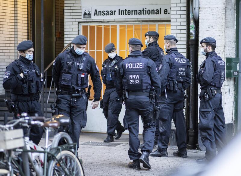 Police officers stay in front of a building of the Ansaar International association in Duesseldorf, Germany, Wednesday, May 5. 2021. The German government on Wednesday banned the Muslim organization. Buildings in 10 German states were raided, according to German news agency dpa, which said that the donations Ansaar collected were donated to welfare projects but also to groups such  as Al-Nusra in Syria, the Palestinians' Hamas group and Al-Shabaab in Somalia. (Marcel Kusch/dpa via AP)