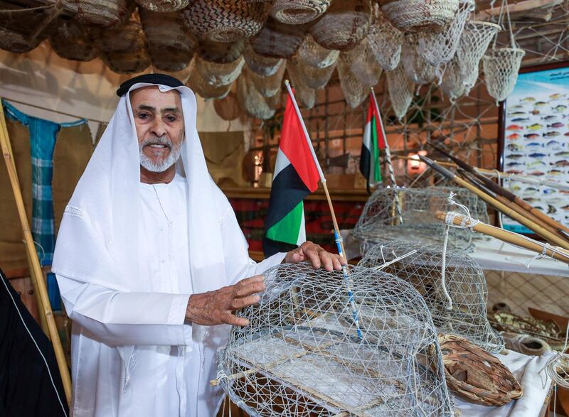 Abu Dhabi, U.A.E., July 18, 2018.  First day of the 2018 Liwa Date Festival. --  Jumaa Hathbour Al Romaithi proudly shows of his Emirati Heritage collection of fishing tools, old coins, knives, picture frames and other collectors items.
Victor Besa / The National
Section:  NA
Reporter:  Haneen Dajani