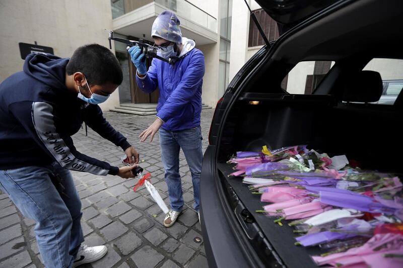 Young men prepare roses to be delivered via drone to women on Mother's day, in Haret Sakher near the coastal city of Jounieh, north of the capital Beirut. AFP